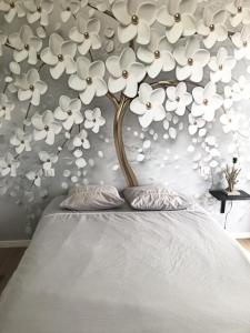 een muur met een boom met witte bloemen erop bij La Villa in Brive-la-Gaillarde