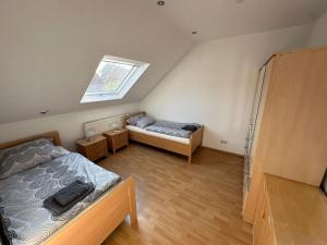 a attic bedroom with two beds and a window at Idyllisches Zechenhaus, auch geeignet als Monteurenwohnung in Essen