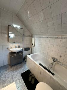 a white bathroom with a sink and a tub and a sinkessment at Idyllisches Zechenhaus, auch geeignet als Monteurenwohnung in Essen