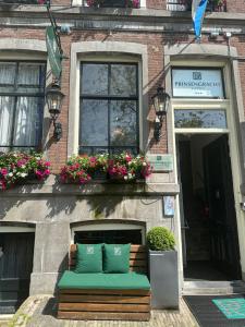 a bench in front of a building with flowers at Prinsengracht Hotel in Amsterdam