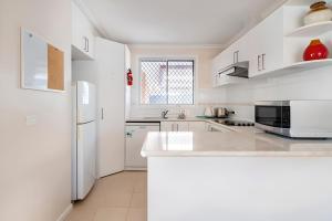 a kitchen with white cabinets and a white refrigerator at Cheerful 3 bedrooms with free parking in Kingswood