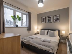 a bedroom with a bed with two tables and a window at Spacious City Sanctuary in Newcastle upon Tyne