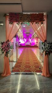 Hotel Silver Inn Executive , Aurangabad في أورانغاباد: ممر مع ممر طويل مع أضواء وردية