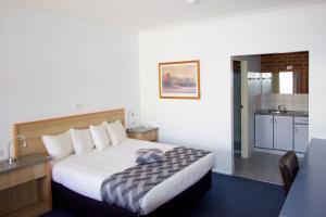 a hotel room with a bed and a kitchen at Albury Paddlesteamer Motel in Albury