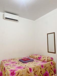 een bed in een kamer met een bloemendeken bij Hotel SANTA CLARA in Belém