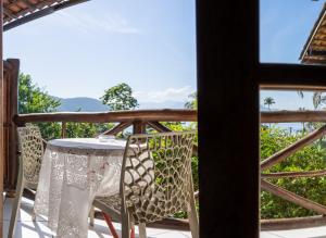 a table and chairs on a balcony with a view at Pousada Aquarela do Mar in Abraão