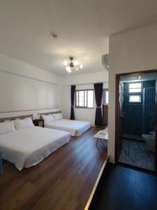 a hotel room with two beds and a bathroom at 小時公館 in Yuli