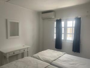 1 dormitorio con cama, escritorio y ventana en Apartamentos Cabrera, en Puerto del Carmen