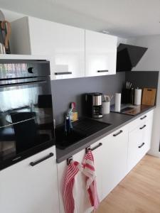 a kitchen with white cabinets and a black stove top oven at Kapitänsliebe in Upleward