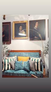 Sofá azul con almohadas en una habitación con pinturas en Art action room 