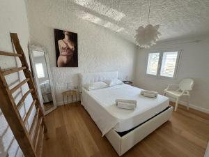 ein weißes Schlafzimmer mit einem Bett und einem Spiegel in der Unterkunft Boutique Art Villa Maria in Olbia