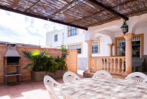 a patio with a table and chairs and a fireplace at Cubo's Villa Paraiso in Alhaurín el Grande