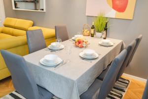 jadalnia ze stołem z krzesłami i żółtą kanapą w obiekcie Casa de Dinca, 2 bedroom, big balcony, free parking zone w Zagrzebiu