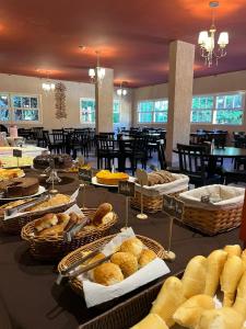 une table remplie de paniers de pain et de viennoiseries dans l'établissement Apart-hotel Nova Friburgo Com café da manhã, à Nova Friburgo