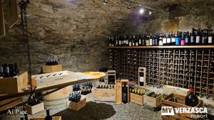 - une salle de dégustation de vin avec un bouquet de bouteilles de vin dans l'établissement MyVerzasca Resort Ai piee, à Brione