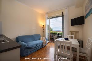 - un salon avec un canapé bleu et une table dans l'établissement Paraggi Apartment by PortofinoVip, à Paraggi