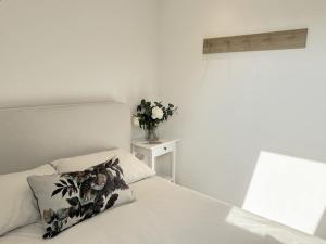 um quarto com uma cama e um vaso de flores sobre uma mesa em The Barn em Chichester