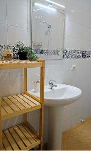 uma casa de banho com um lavatório e um espelho em Apartamentos home Chipiona em Chipiona