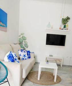 uma sala de estar com um sofá e uma mesa em Apartamentos home Chipiona em Chipiona
