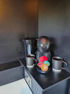 a counter with two coffee mugs and two cups at City Centre Room in Chester +3 photos