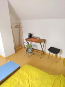 Zimmer mit einem Schreibtisch und einem Tisch mit einem Bett in der Unterkunft Escale Élégante à Héricourt in Héricourt