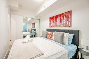 a bedroom with a bed and a painting on the wall at Stylish 2BR Condo in Proximity to City Center in Toronto
