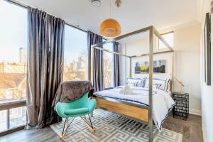 um quarto com uma cama de dossel e uma cadeira azul em Luxury 2BR Unit - Heart of the Chinatown em Toronto