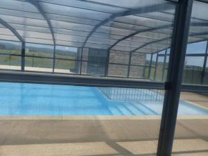 une vue d'une piscine à travers une fenêtre dans l'établissement Cottage du Lac, à Olonzac