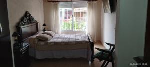 1 dormitorio con cama y ventana en Mi casita en Tandil