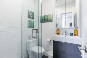 La salle de bains est pourvue de toilettes, d'un lavabo et d'un miroir. dans l'établissement Spacious 2BR Apartment - Minutes to Leslieville, à Toronto