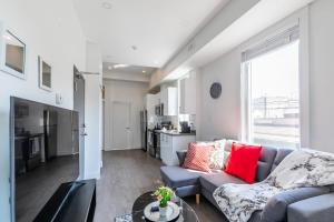 a living room with a couch and a table at Spacious 2BR Apartment - Minutes to Leslieville in Toronto