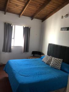 una camera con un letto blu e una finestra di Mamama’s House a Puerto Madryn