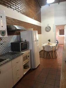 Il comprend une cuisine équipée d'un réfrigérateur blanc et d'une table. dans l'établissement Mamama’s House, à Puerto Madryn