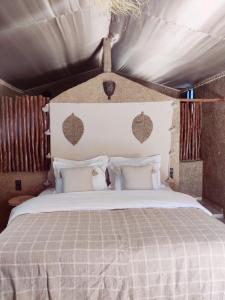 1 dormitorio con 1 cama grande en una tienda de campaña en Zagora Oasis Lodge, en Zagora