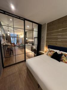 a bedroom with a large bed and a living room at Magnifica vivienda a estrenar junto a Plaza España in Valencia