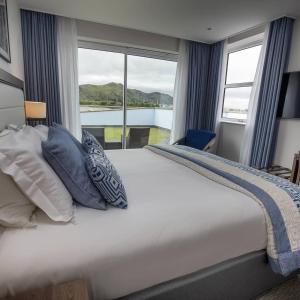 um quarto com uma cama grande com almofadas e uma janela em The Quay Hotel and Spa em Conwy