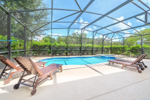 a swimming pool with two chairs and a glass roof at Solterra Resort Home - Waterslide and Lazy River in Davenport