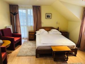 - une chambre avec un lit, un canapé et une chaise dans l'établissement Erene Hotel, à Câmpulung Moldovenesc