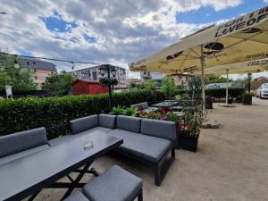 a patio with a couch and tables and an umbrella at Albert Hotel in Roşu
