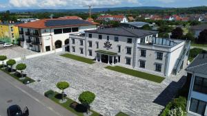 eine Luftansicht auf ein großes weißes Gebäude mit einem Innenhof in der Unterkunft Hotel Sleep & Dream Nähe Europa Park und Rulantica in Ringsheim