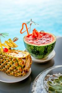 a table topped with a watermelon and a bowl of food at Premier Pearl Hotel Vung Tau in Vung Tau