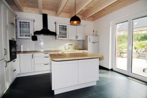 a kitchen with white cabinets and a kitchen island at Kugelberg 13 in Heiligenhafen