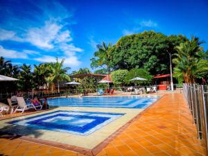 uma piscina num resort com palmeiras em Hotel campestre las palmas em Villavicencio
