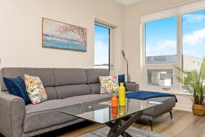 sala de estar con sofá y mesa de cristal en Stylish 2BR Condo - Balcony - Stunning City View, en Kitchener