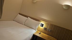 a small bedroom with a bed and a wooden table at Exhibition Court Hotel 4 in London