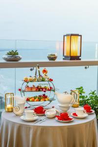頭頓的住宿－Premier Pearl Hotel Vung Tau，一张桌子,上面放着一盘食物和一块蛋糕