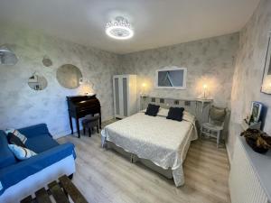 a bedroom with a bed and a piano at Maison du Manoir in Vallon-Pont-dʼArc