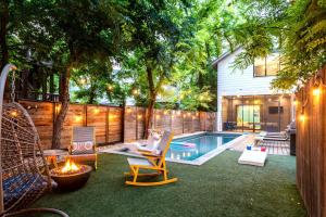 a backyard with a pool and chairs and a house at Backyard Pool Oasis - Rainey Street - 6 min walk in Austin