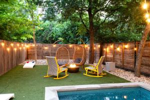 a backyard with chairs and a pool with lights at Backyard Pool Oasis - Rainey Street - 6 min walk in Austin +32 photos