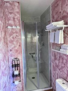 La salle de bains est pourvue d'une douche avec une porte en verre. dans l'établissement Maison du Manoir, à Vallon-Pont-dʼArc